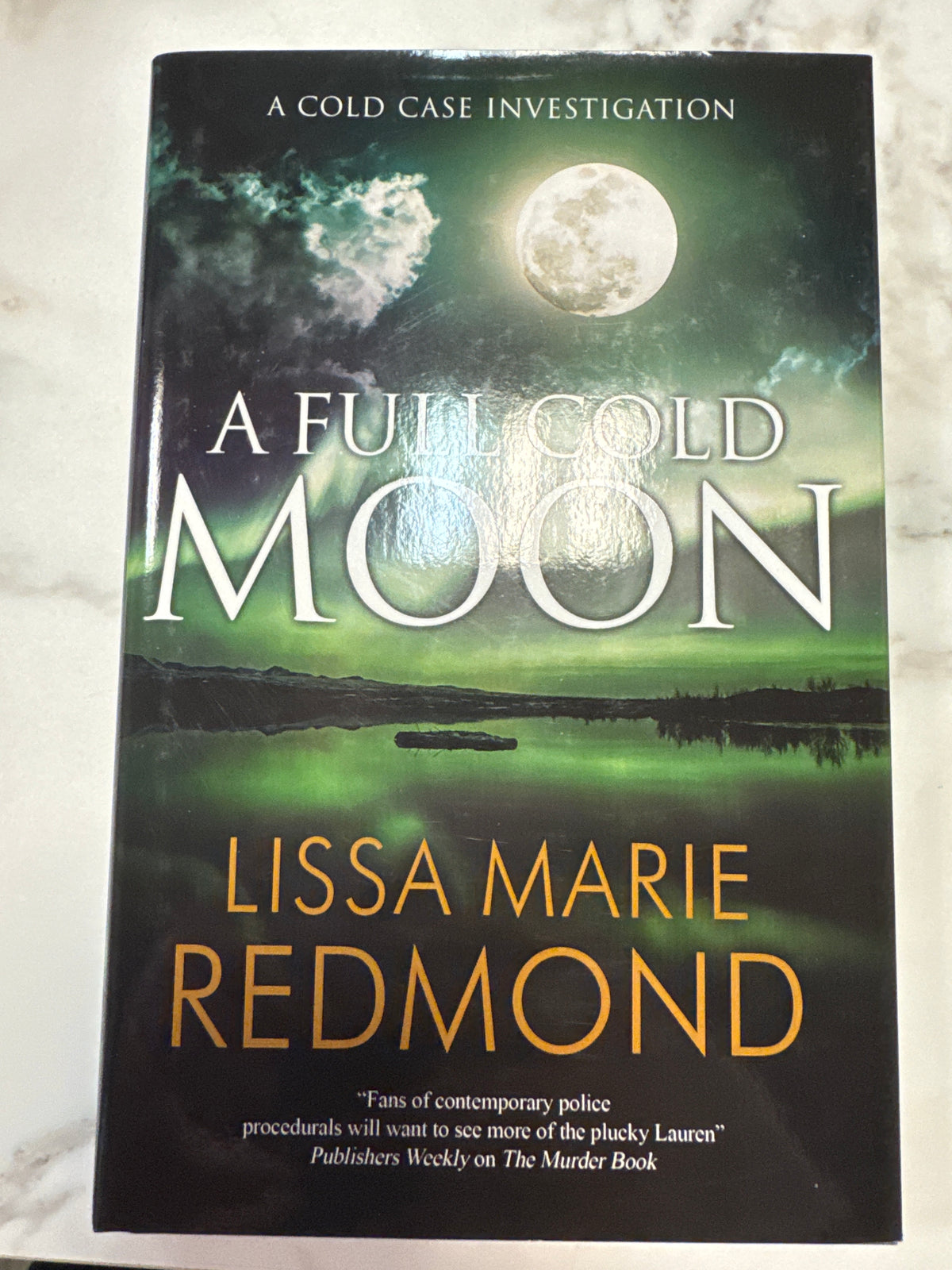 A Full Cold Moon hardcover book by Lissa Marie Redmond with moon and aurora borealis cover art