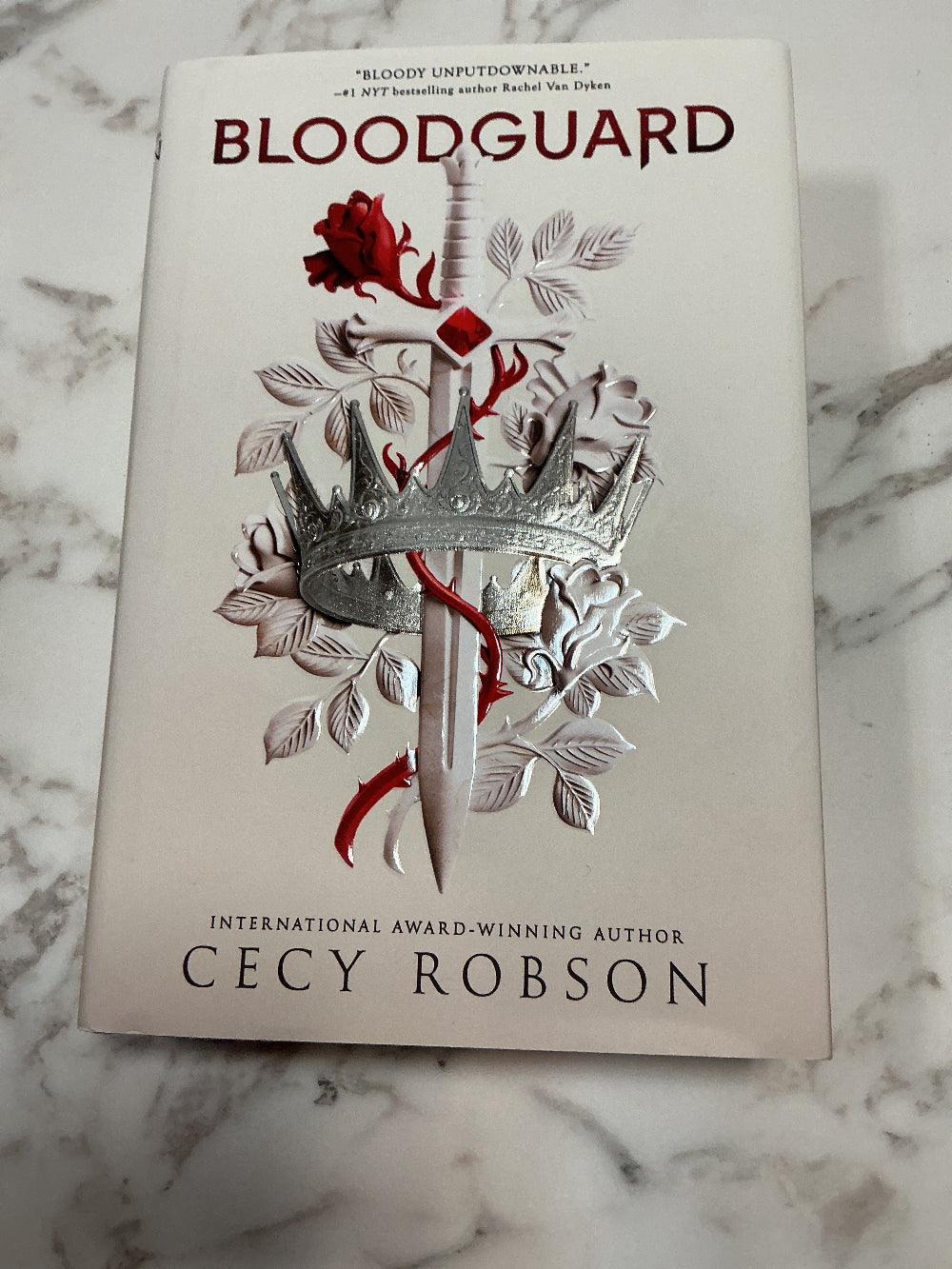 Book titled 'Bloodguard' by Cecy Robson on a marble surface