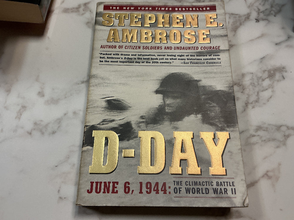 Book titled 'D-Day' by Stephen E. Ambrose on a marble surface
