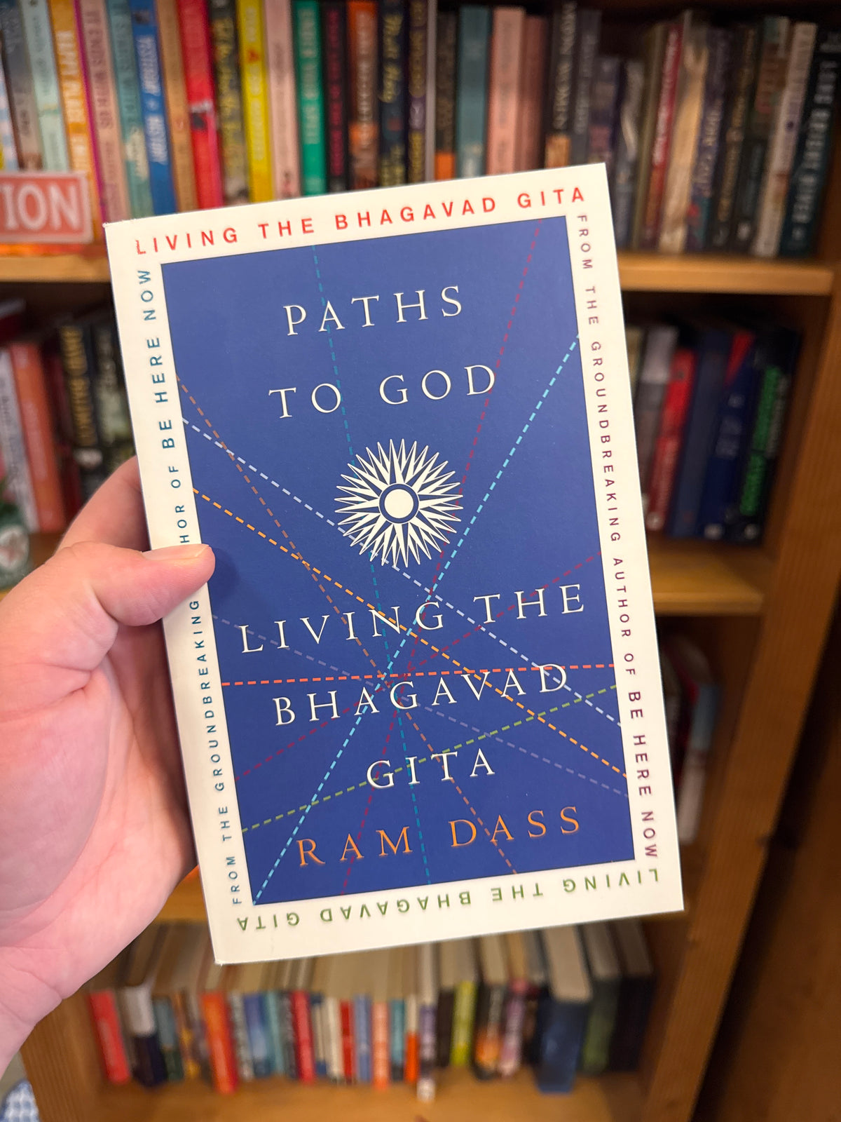 Living the Bhagavad Gita paperback by Ram Dass with blue cover and sunburst design