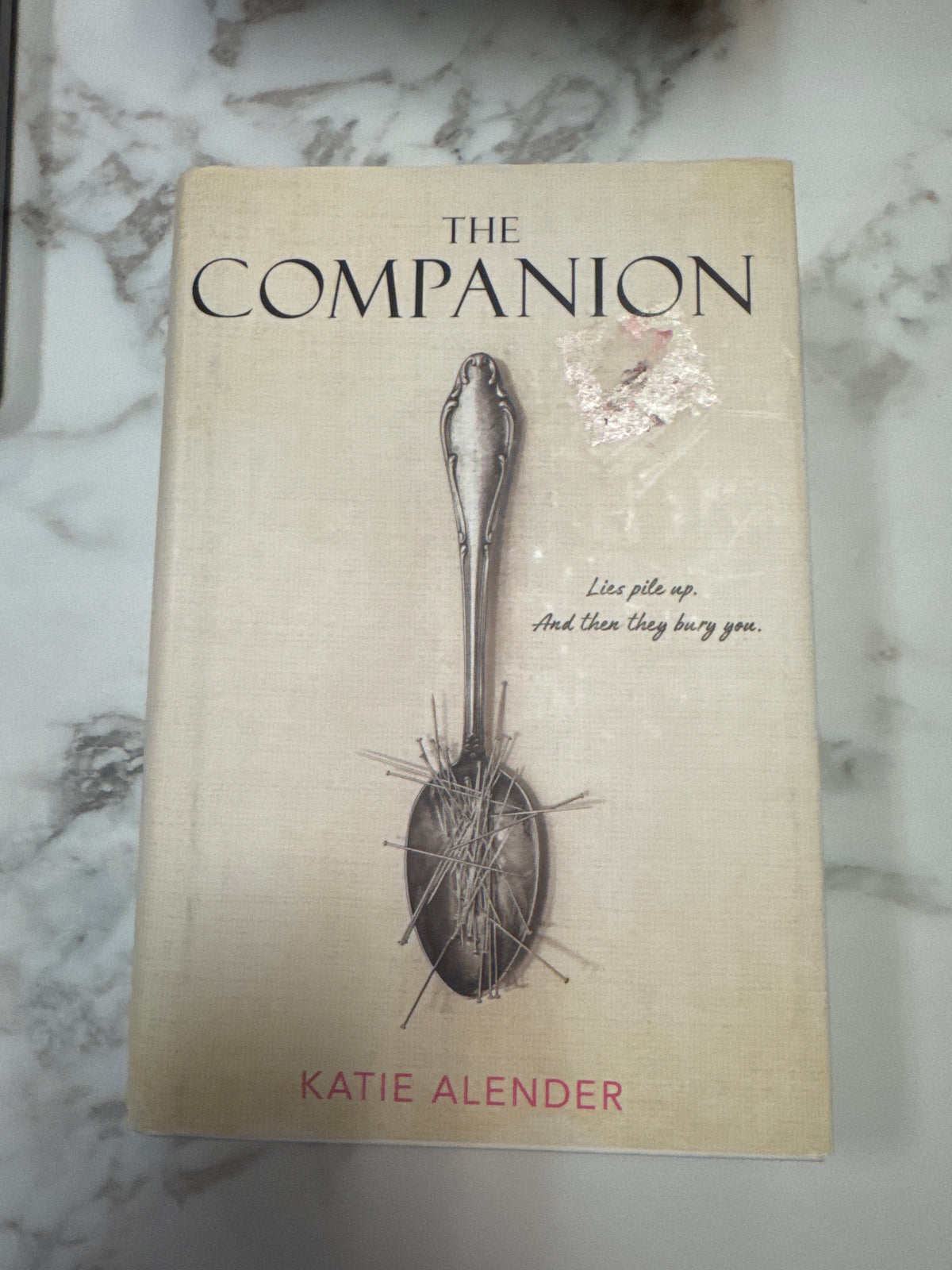 The Companion hardcover book by Katie Alender with cream textured cover and silver spoon illustration