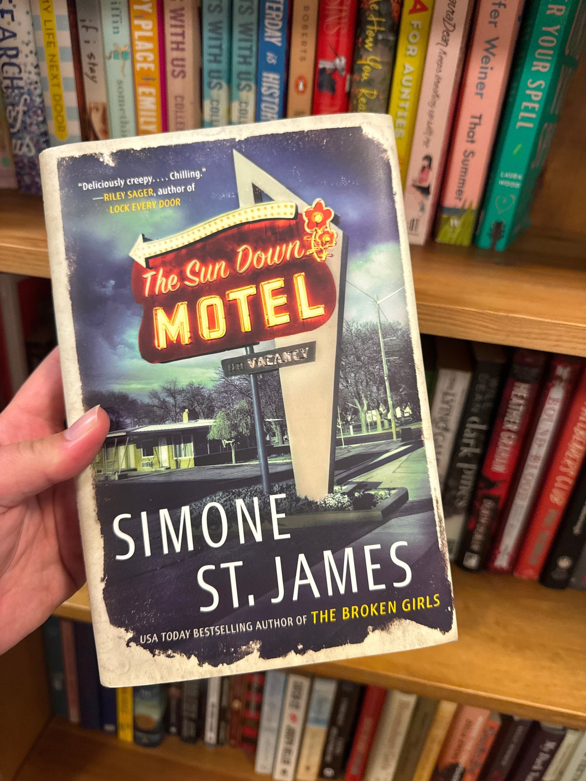The Sun Down Motel paperback by Simone St. James with retro neon motel cover art