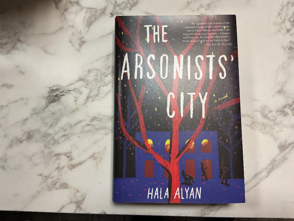 Book titled 'The Arsonists' City' by Hala Alyan on a marble surface