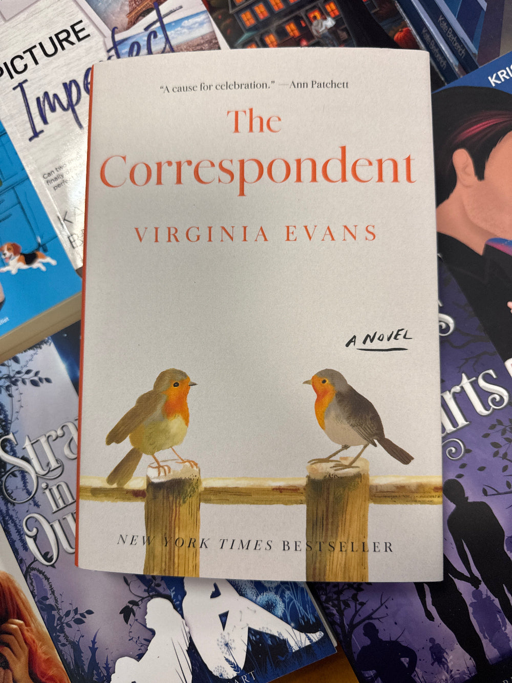 Book titled 'The Correspondent' by Virginia Evans with a bird illustration on a colorful background.