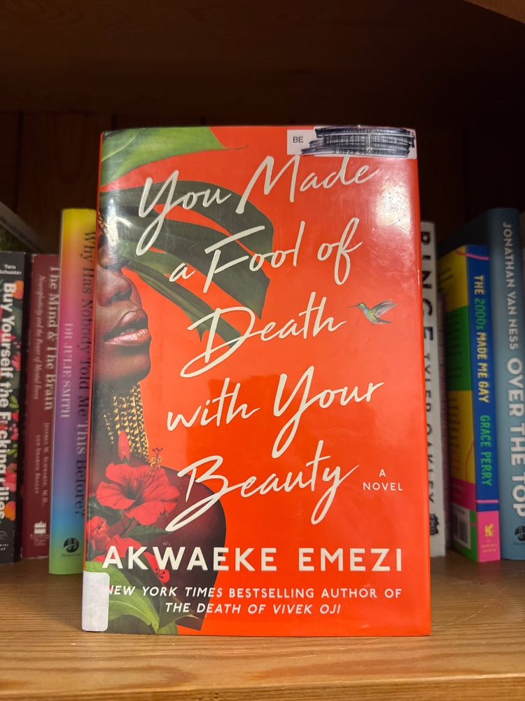 You Made a Fool of Death with Your Beauty hardcover novel by Akwaeke Emezi, orange cover with tropical leaf and hummingbird design