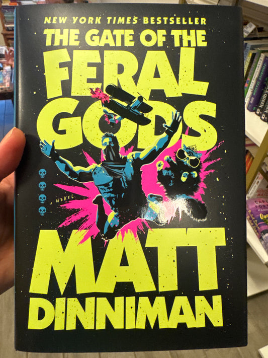 The Gate of the Feral Gods hardcover book by Matt Dinniman, black cover with neon yellow title and fantasy illustration