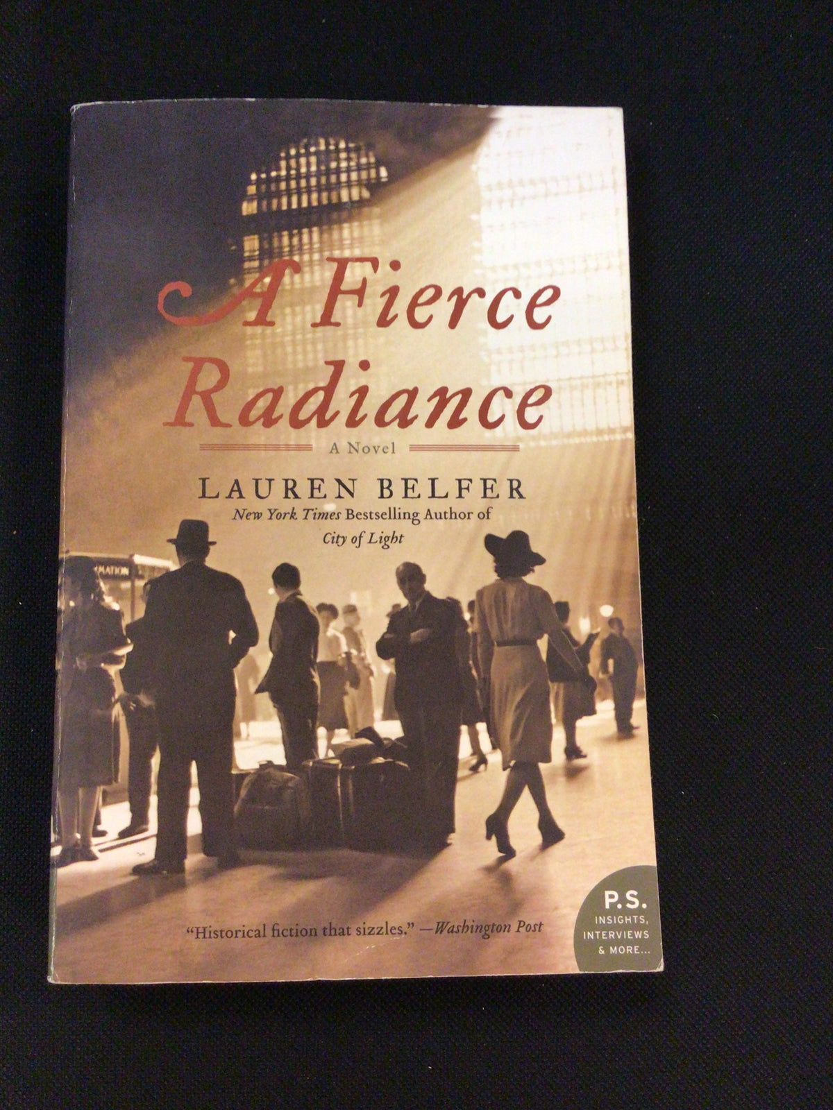 A Fierce Radiance paperback novel by Lauren Belfer with sepia-toned 1930s train station cover art