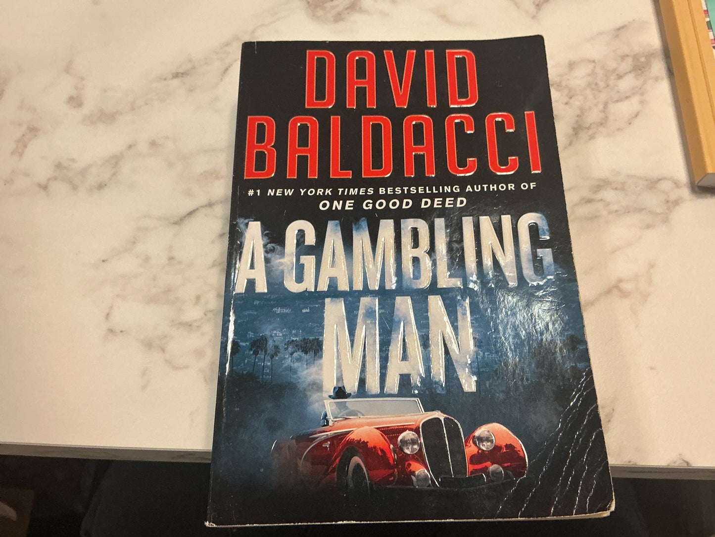 Book titled 'A Gambling Man' by David Baldacci on a marble surface