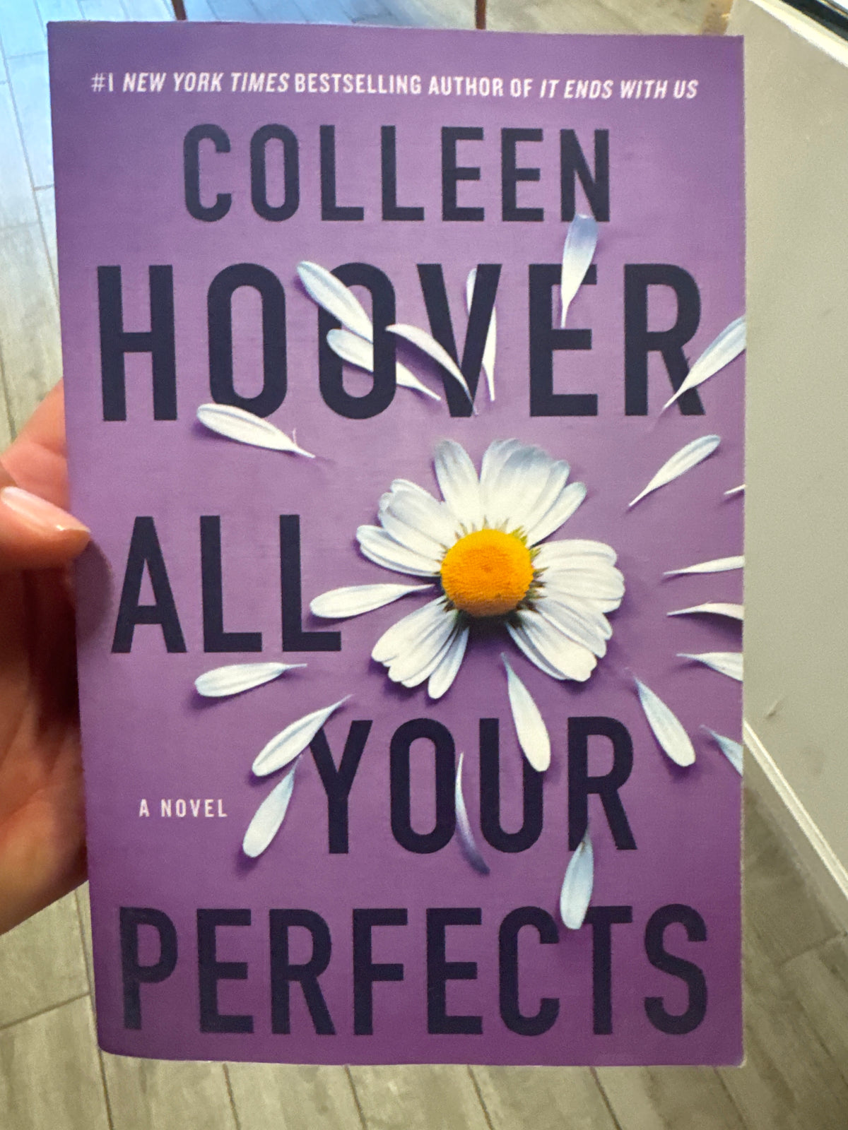 Purple paperback book All Your Perfects by Colleen Hoover with white daisy cover design