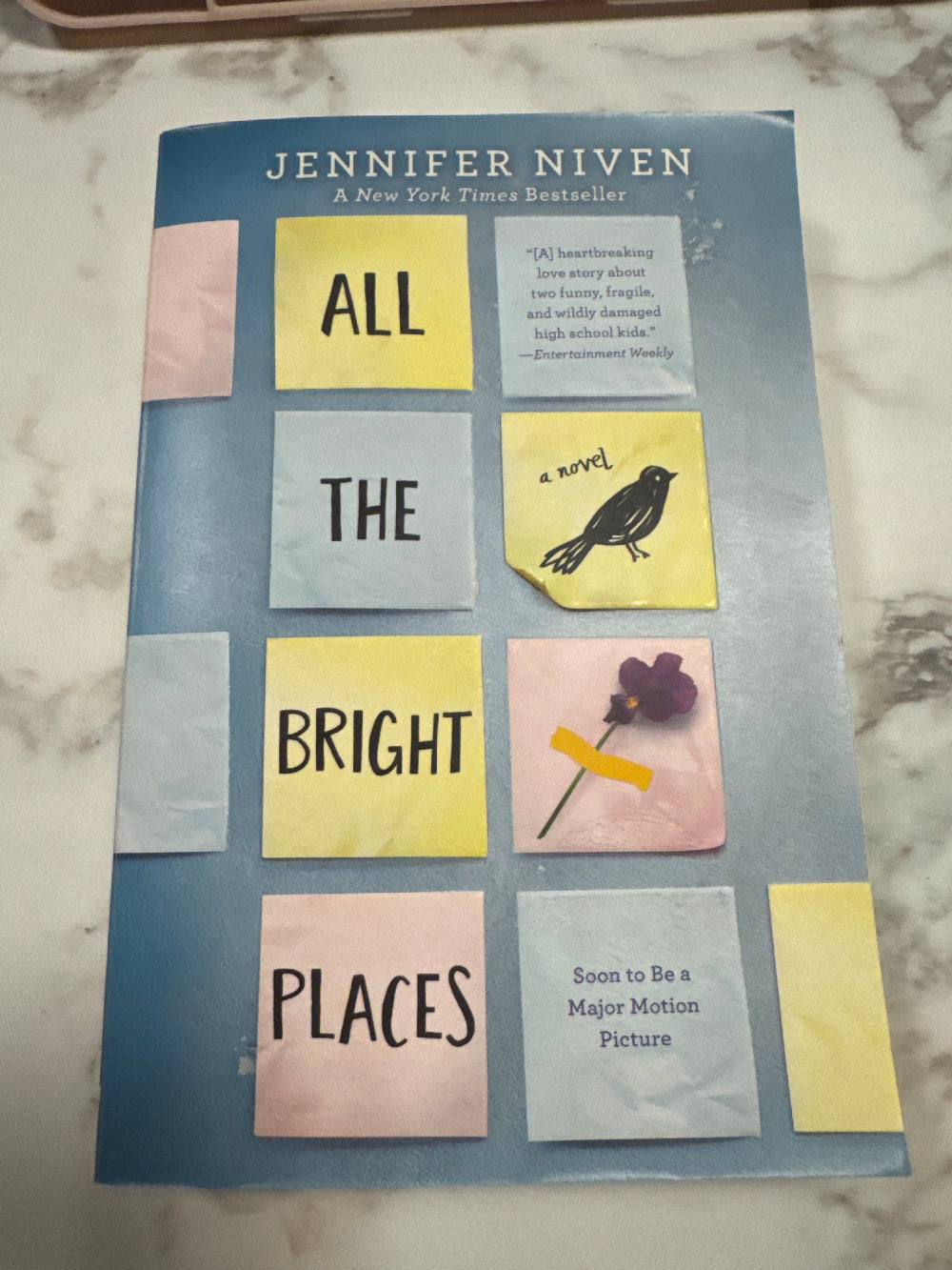 Book cover of 'All the Bright Places' by Jennifer Niven on a marble surface