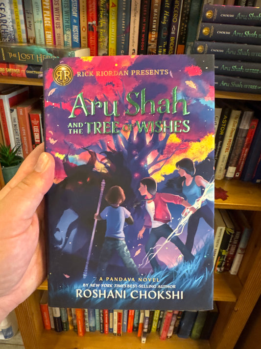 Aru Shah and the Tree of Wishes hardcover book by Roshani Chokshi held in hand