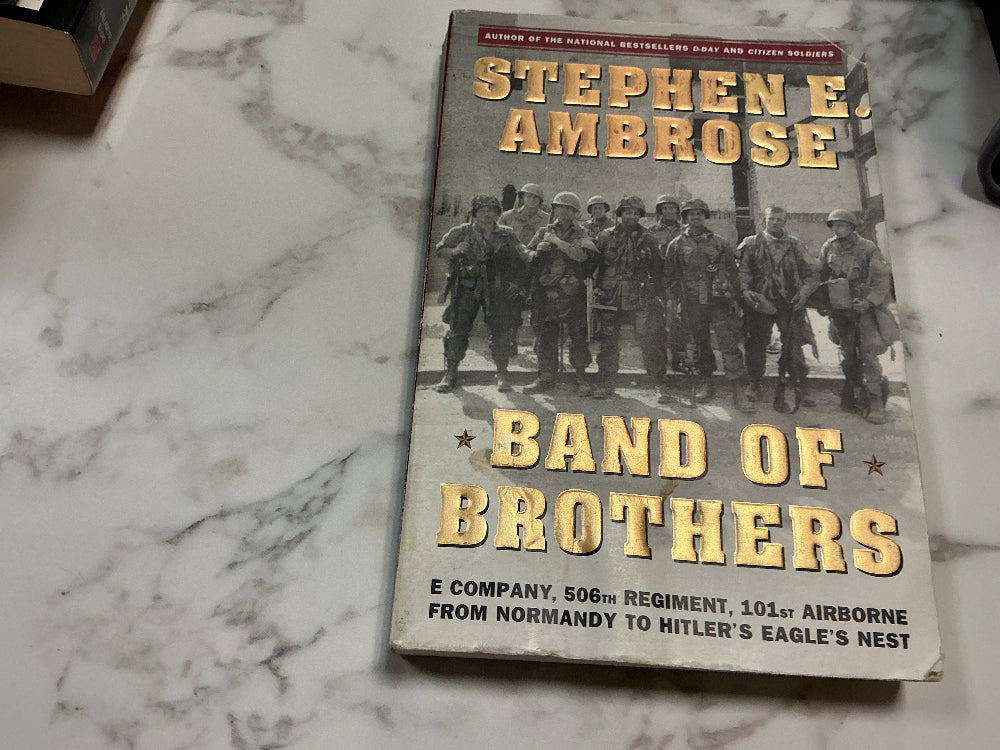 Book titled 'Band of Brothers' by Stephen E. Ambrose on a marble surface