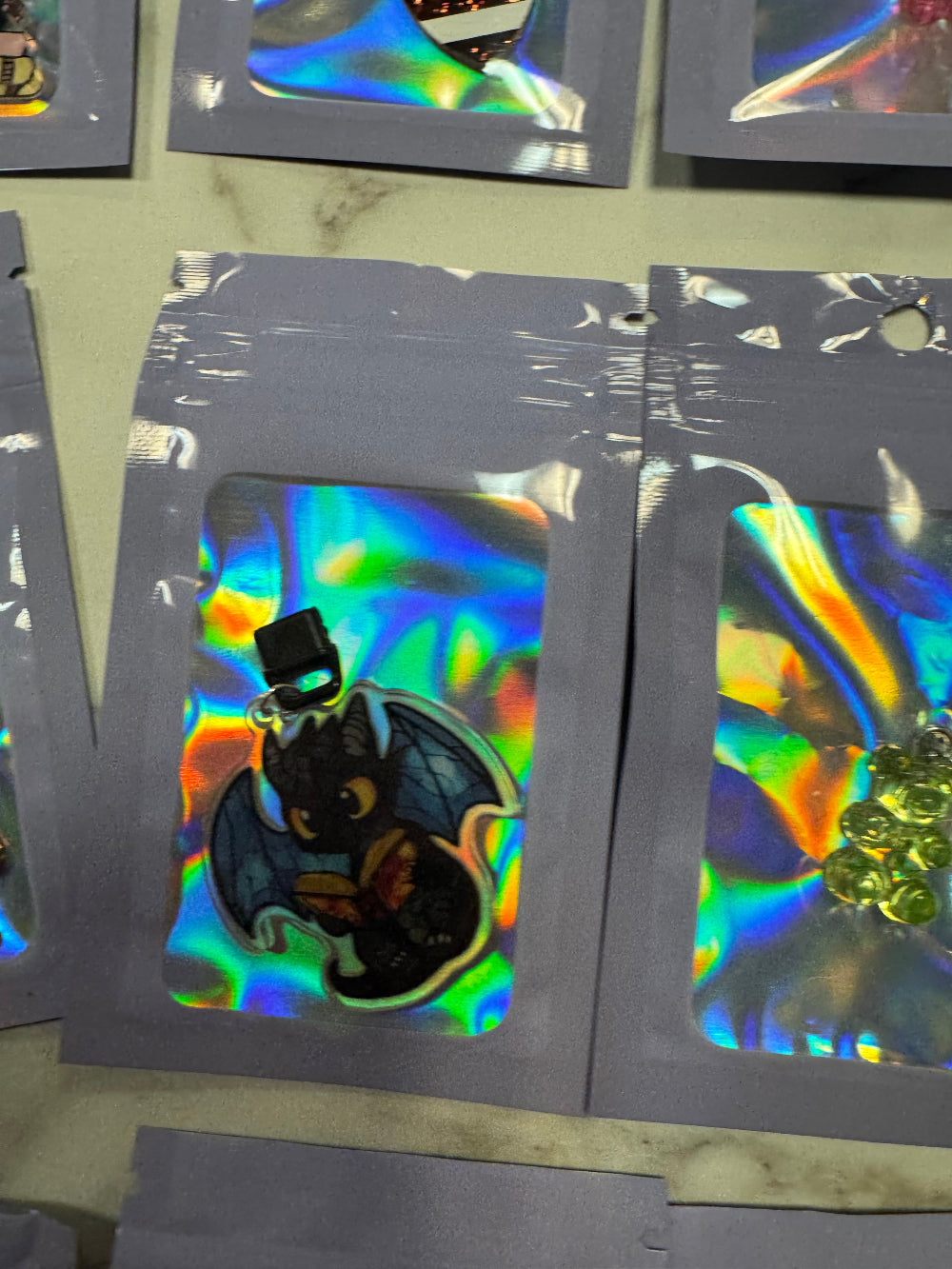 Holographic packaging with dragon kindle charm in it