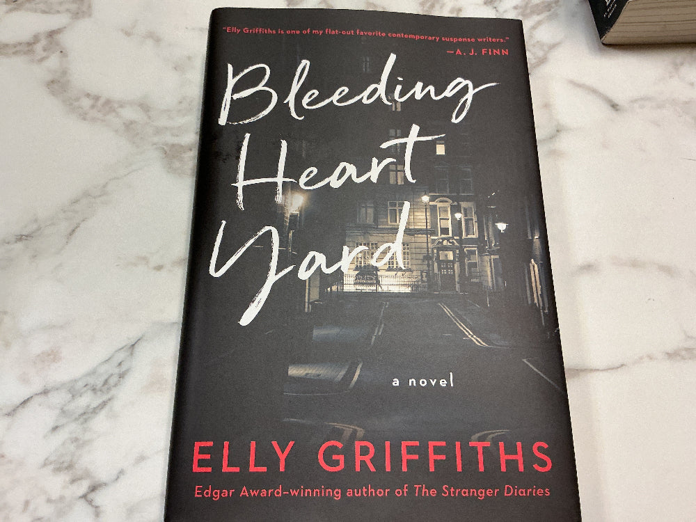 Book titled 'Bleeding Heart Yard' by Elly Griffiths on a marble surface