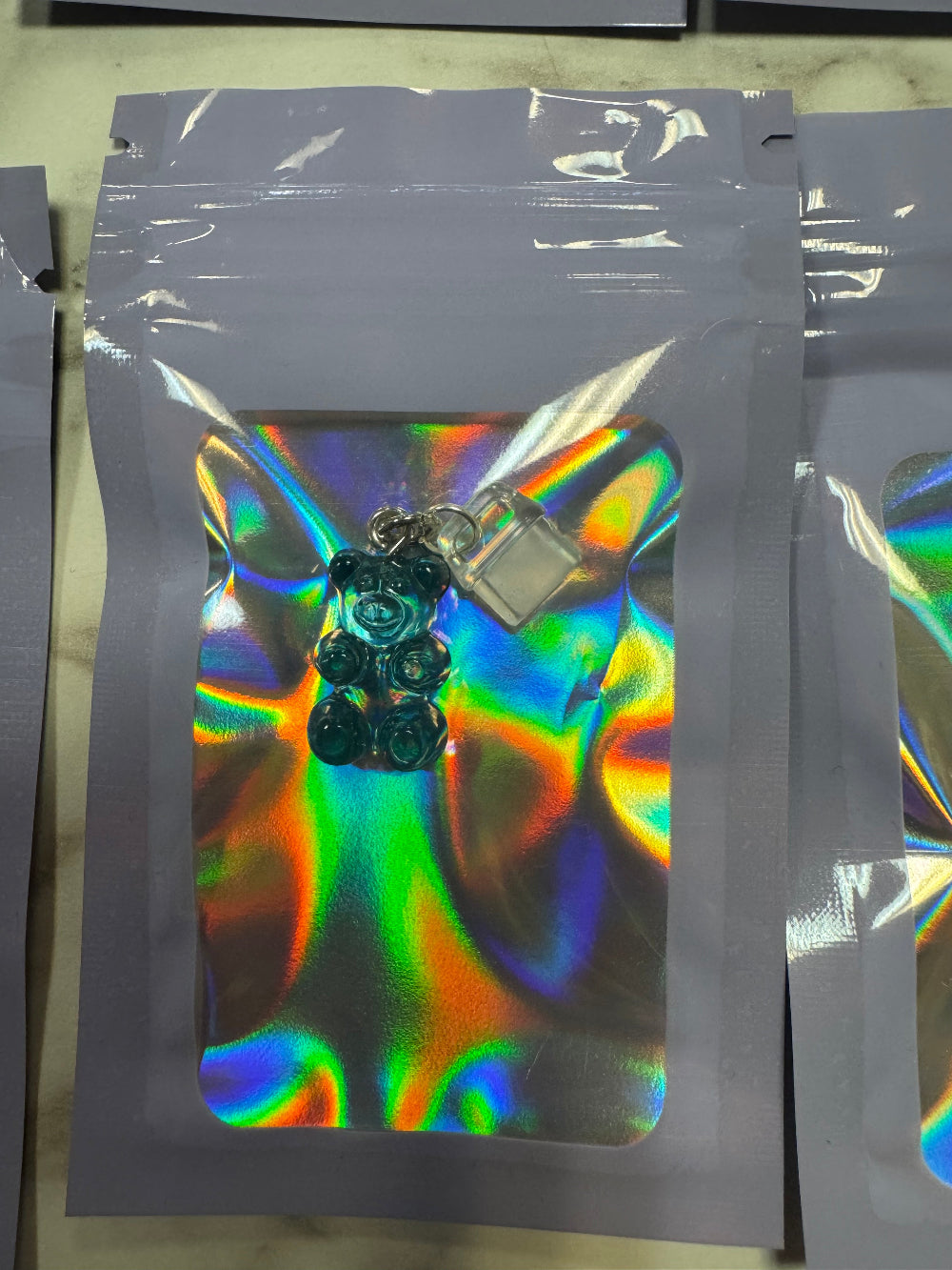 Holographic packaging with Blue Gummy Bear Kindle Charm Inside