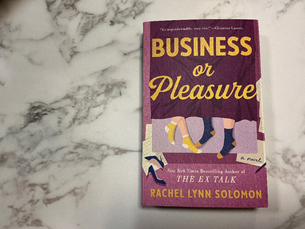 Book titled 'Business or Pleasure' by Rachel Lynn Solomon on a marble surface