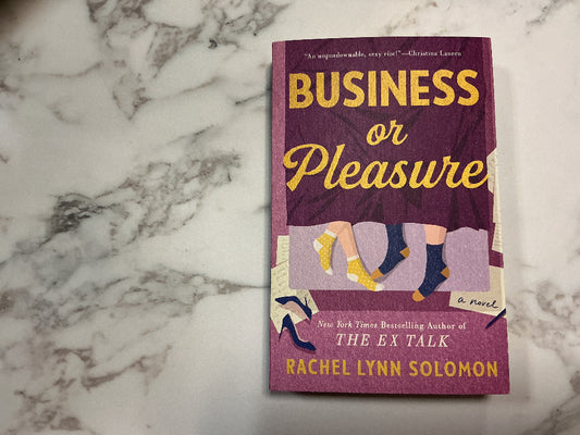 Book titled 'Business or Pleasure' by Rachel Lynn Solomon on a marble surface