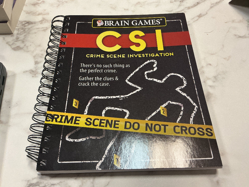 Notebook with CSI Crime Scene Investigation cover on a marble surface