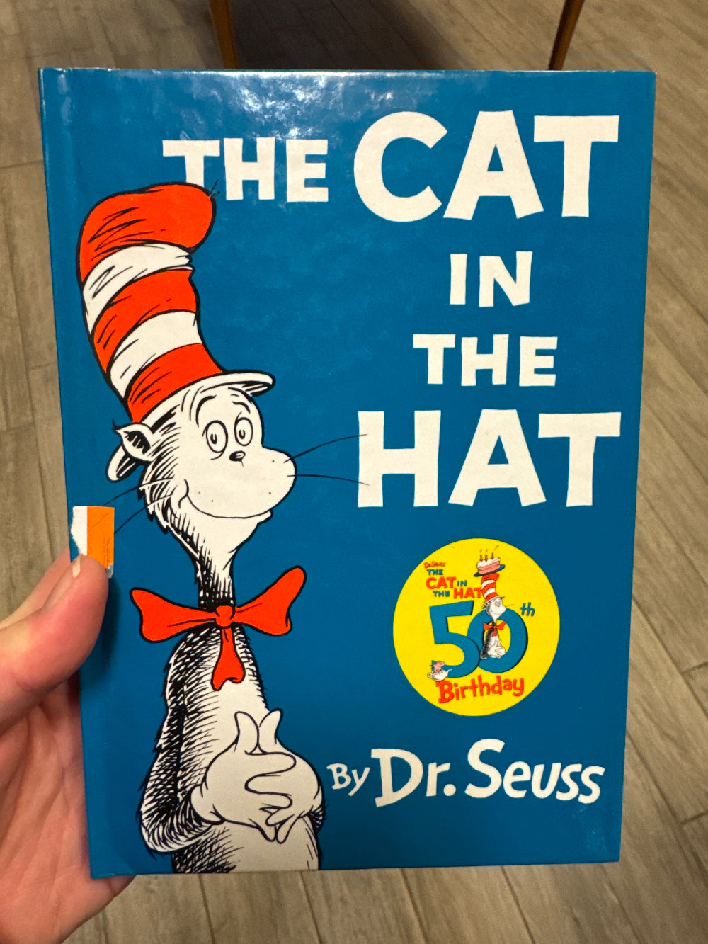 Book titled 'The Cat in the Hat' by Dr. Seuss on a wooden surface