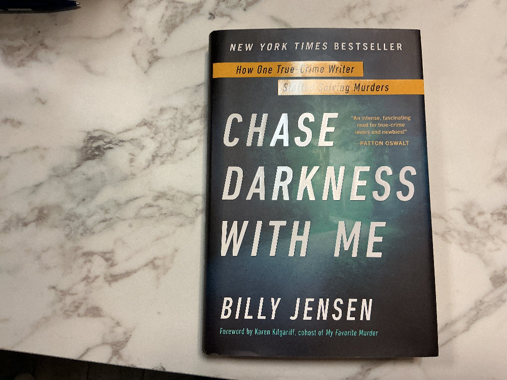 Book titled 'Chase Darkness with Me' by Billy Jensen on a marble surface