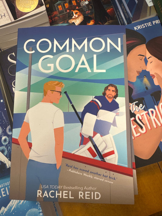 Book titled 'Common Goal' by Rachel Reid on a stack of other books.