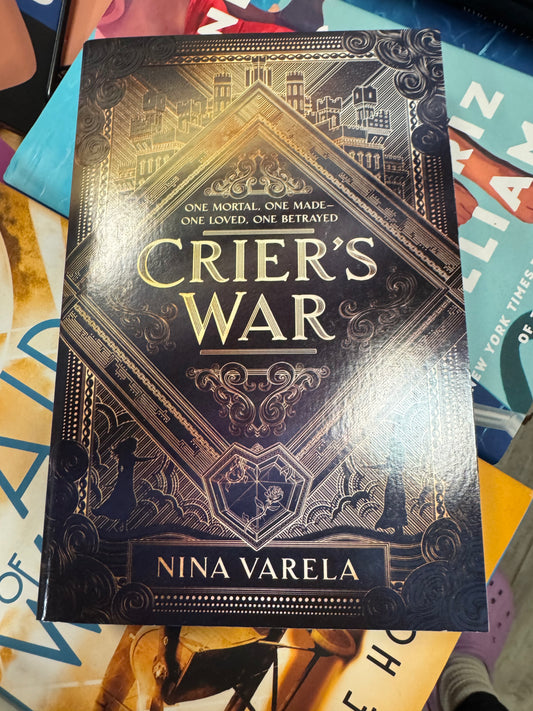 Crier's War hardcover book by Nina Varella with navy cover and gold foil cityscape design