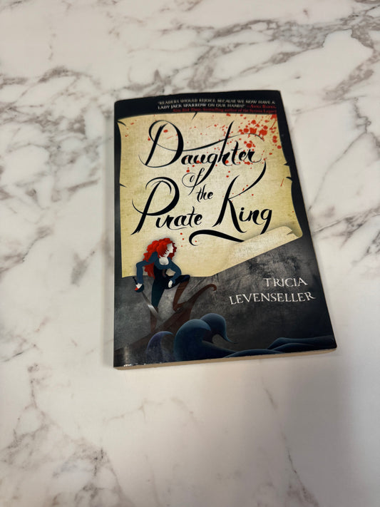 Daughter of the Pirate King paperback by Tricia Levenseller on marble