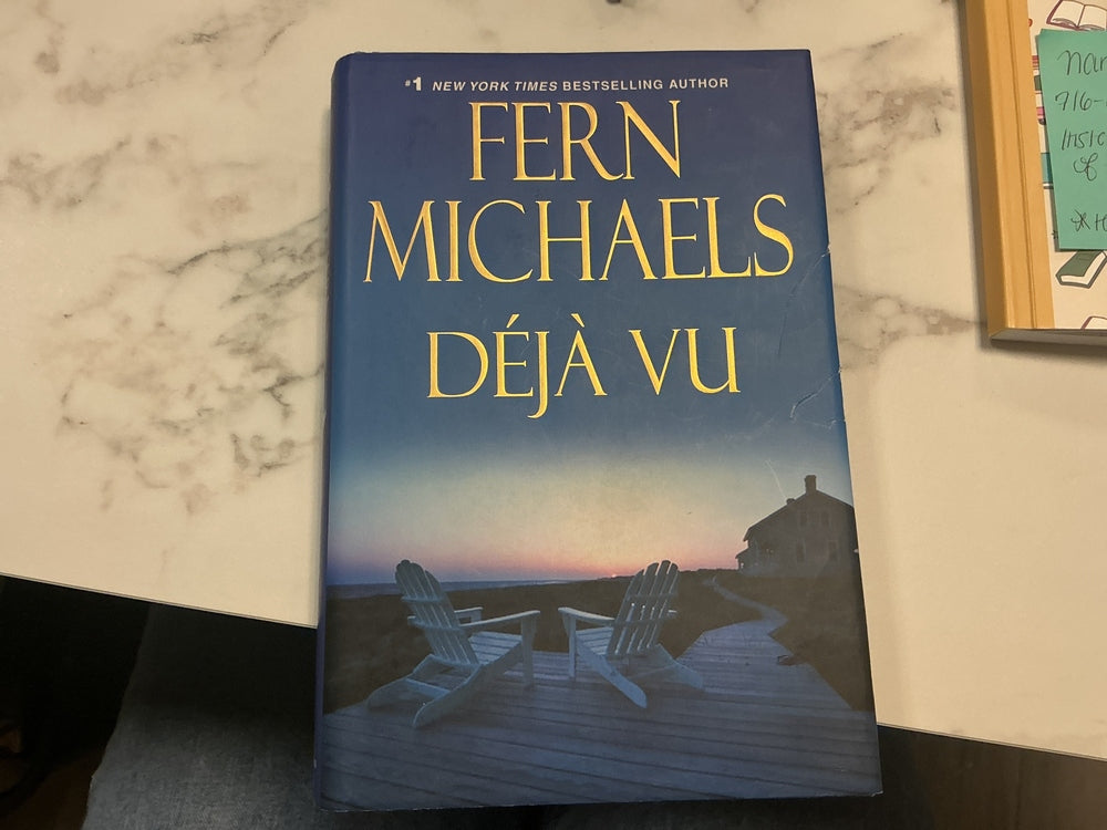 Book titled 'Déjà Vu' by Fern Michaels on a marble surface
