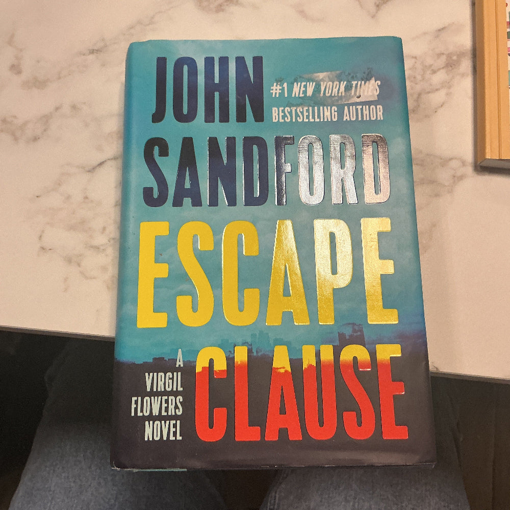 Book titled 'Escape Clause' by John Sandford on a marble surface