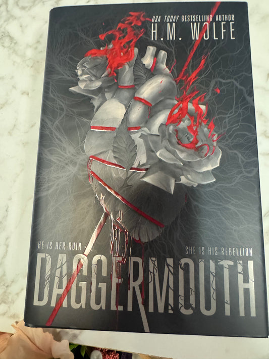 Daggermouth hardcover book by H.M. Wolfe with silver heart and red ribbon cover design