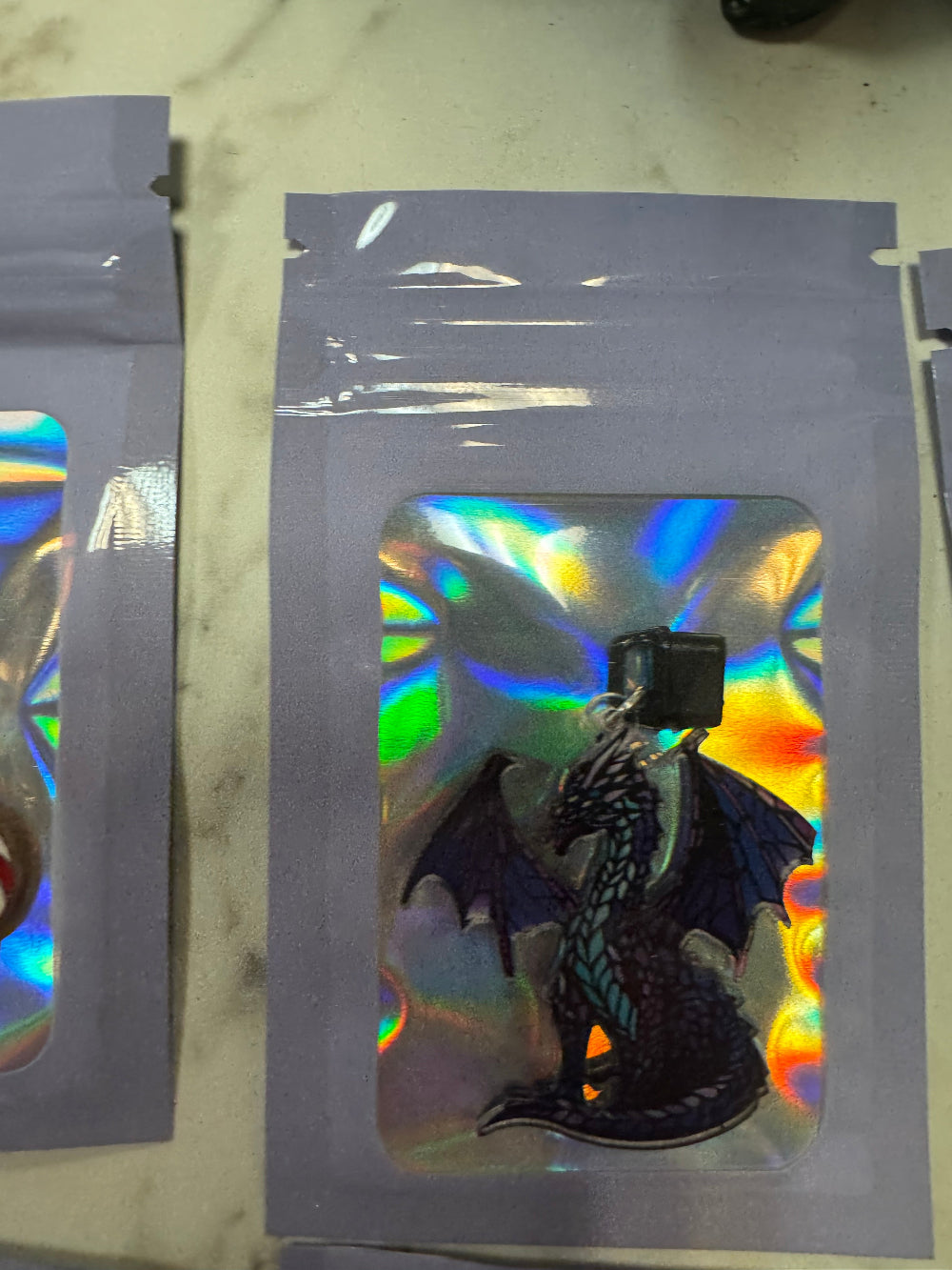 Holographic packaging with blue dragon kindle charm inside