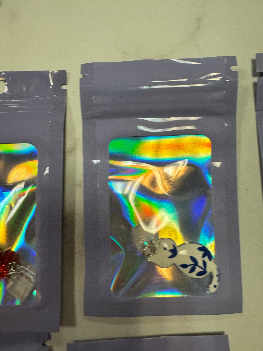Holographic packaging with white and blue cat kindle charm inside