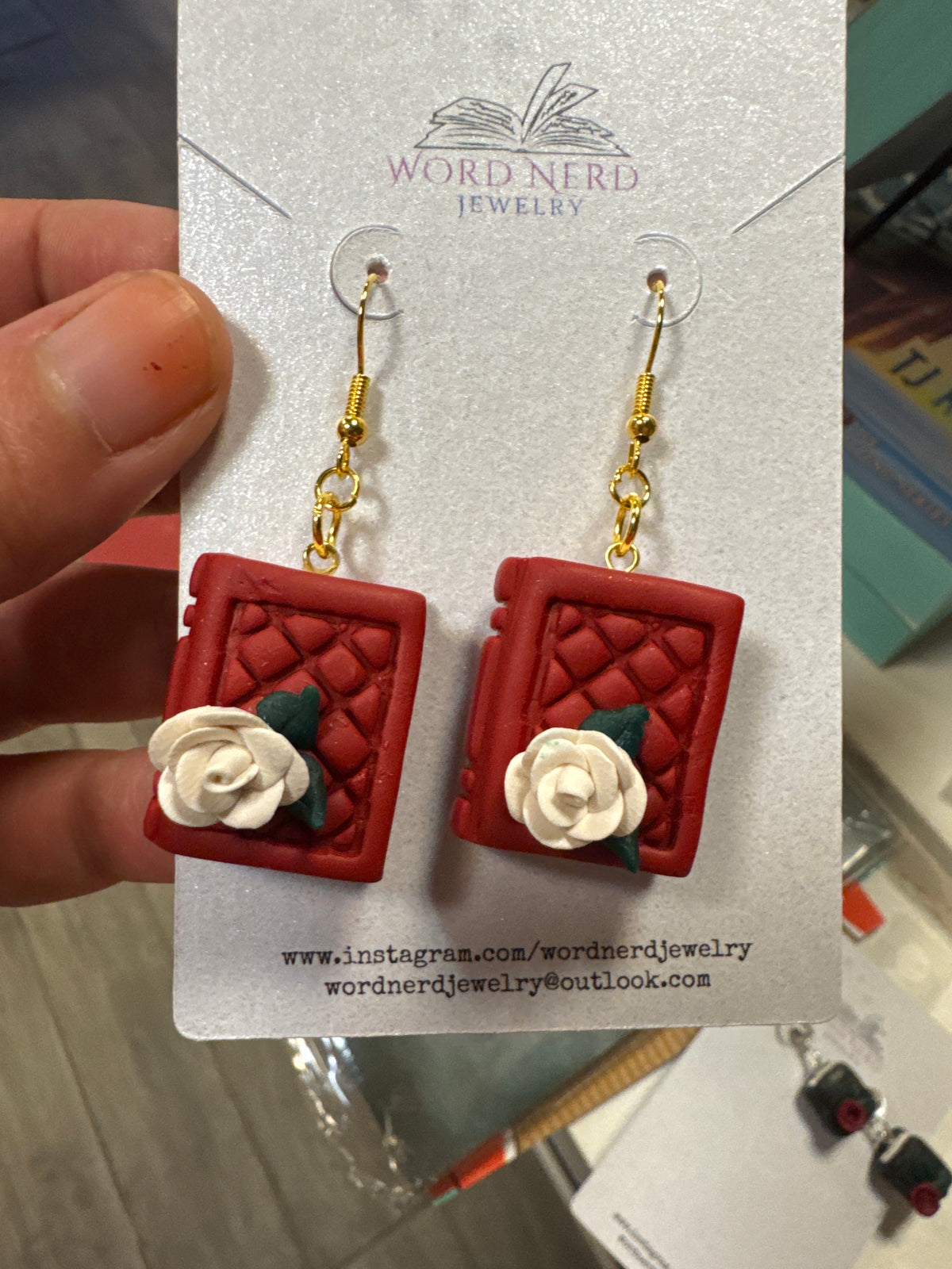 Red polymer clay book earrings with quilted texture and rose details on gold hooks