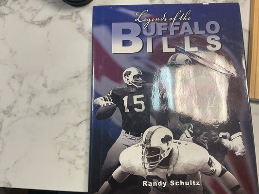 Book titled 'Legends of the Buffalo Bills' by Randy Schultz on a marble surface.