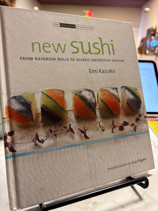 Book titled 'New Sushi' with images of sushi on the cover, placed on a surface.