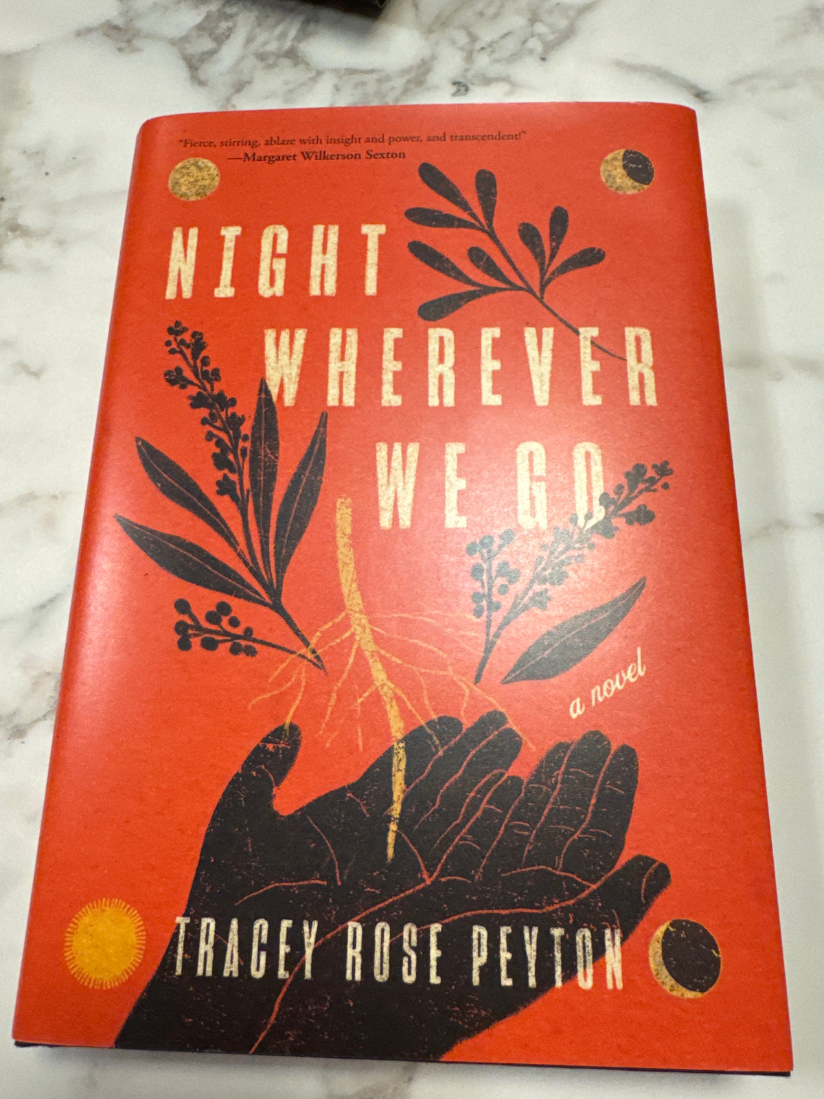 Night Wherever We Go hardcover book by Tracey Rose Peyton with orange-red cover and gold foil botanical design