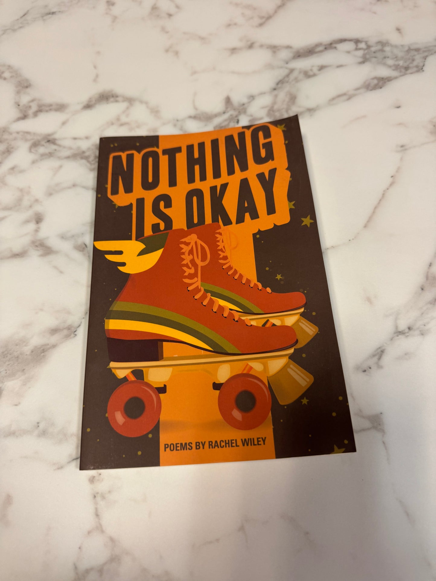 Nothing Is Okay book with retro orange roller skate illustration on dark brown cover