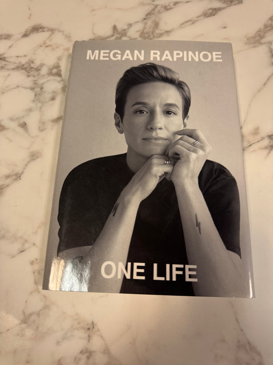 One Life hardcover book by Megan Rapinoe on marble surface
