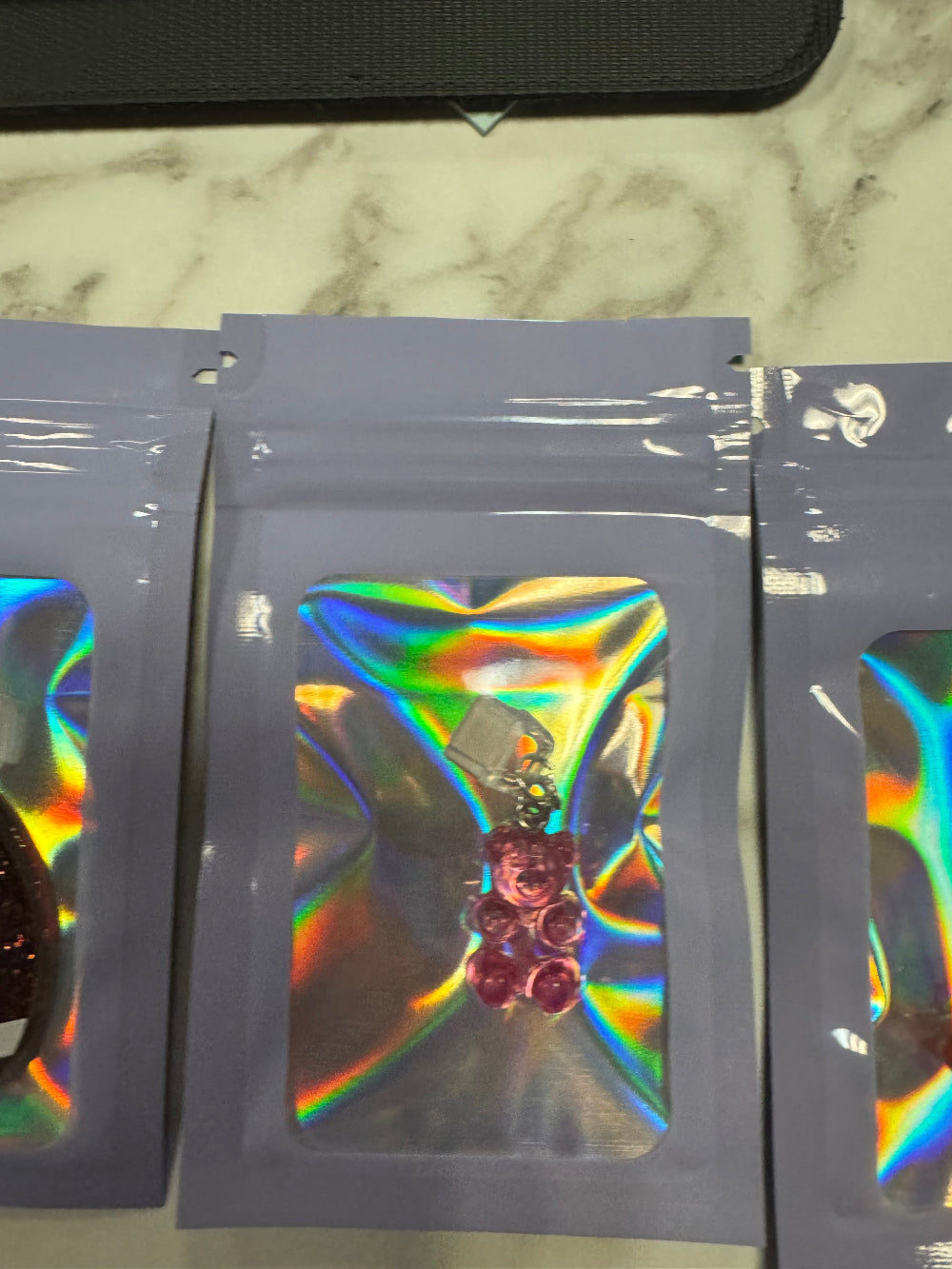 Holographic packaging with pink gummy bear kindle charm inside