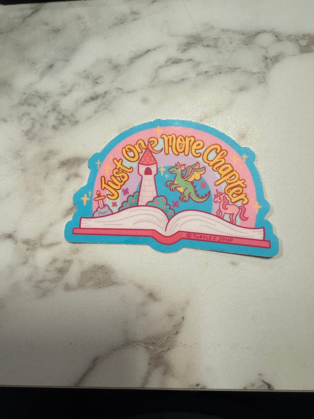 Colorful sticker with text and graphics on a marble surface