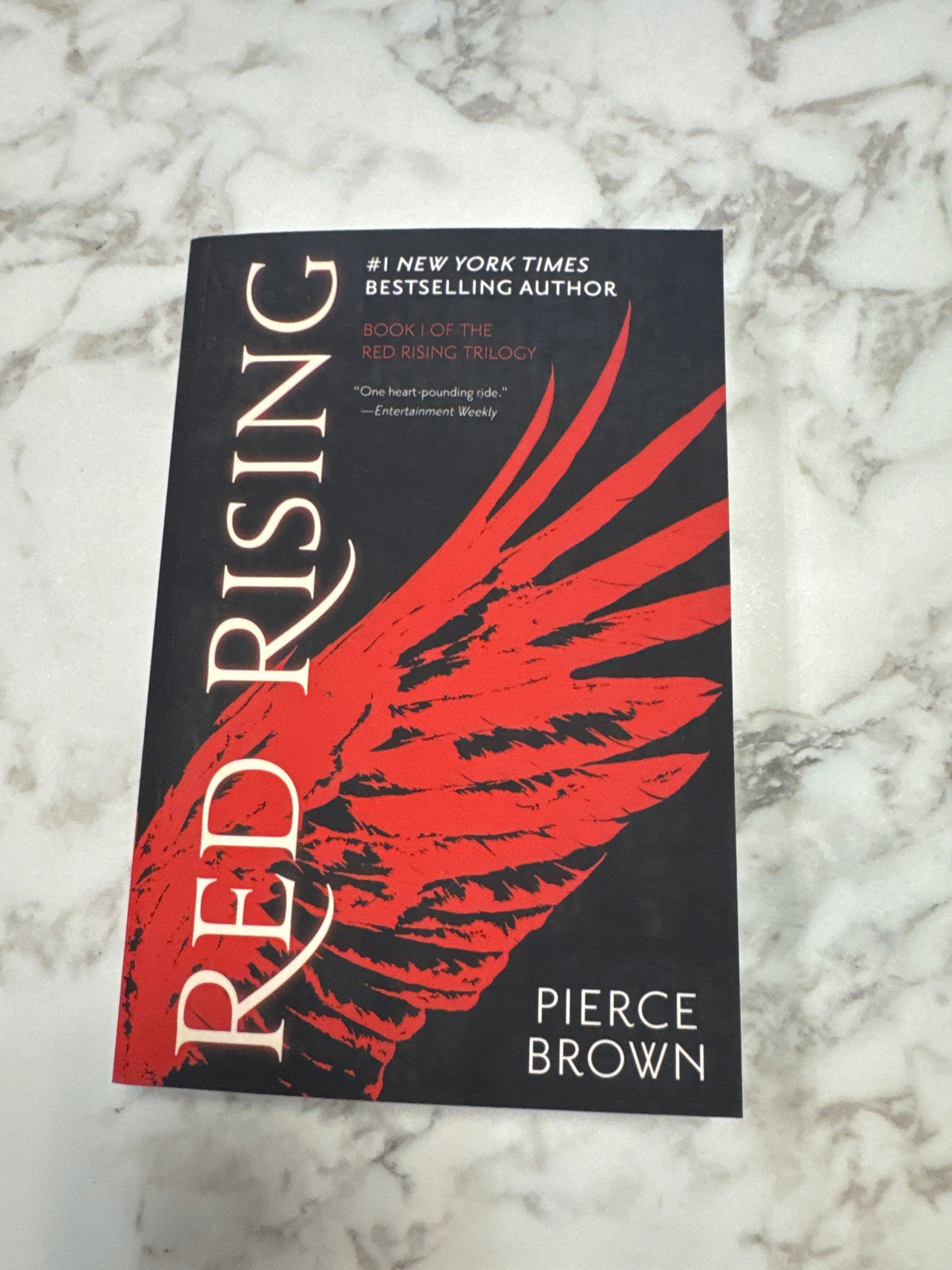 Red Rising hardcover book by Pierce Brown with red wing cover design