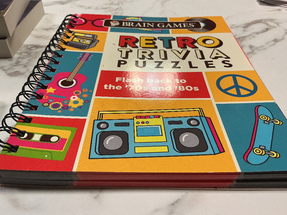 Book titled 'Retro Trivia Puzzles' with 70s/80s theme design on a marble surface
