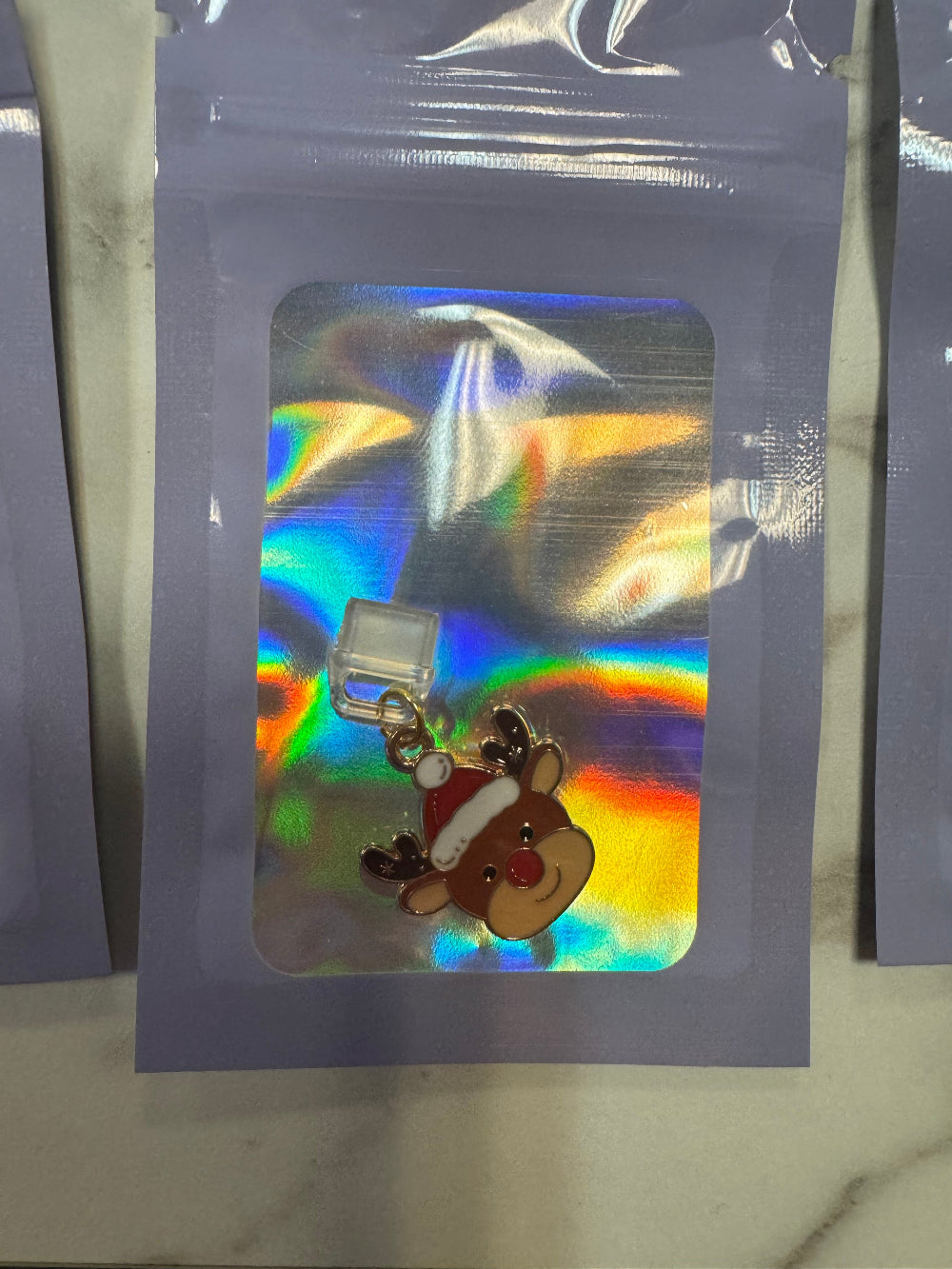 Holographic packaging with Rudolph the red nosed reindeer kindle charm inside