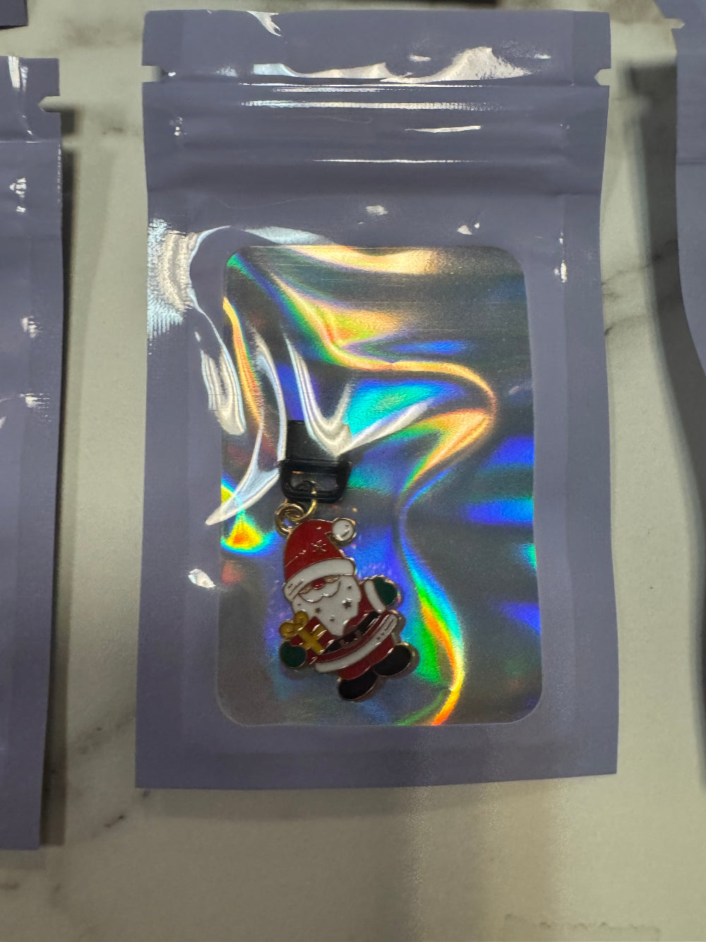 Holographic packaging with Santa Kindle Charm inside