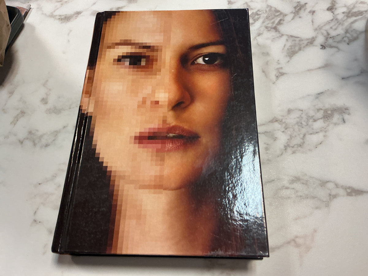 Second Life hardcover book with split-face pixelated cover art on marble