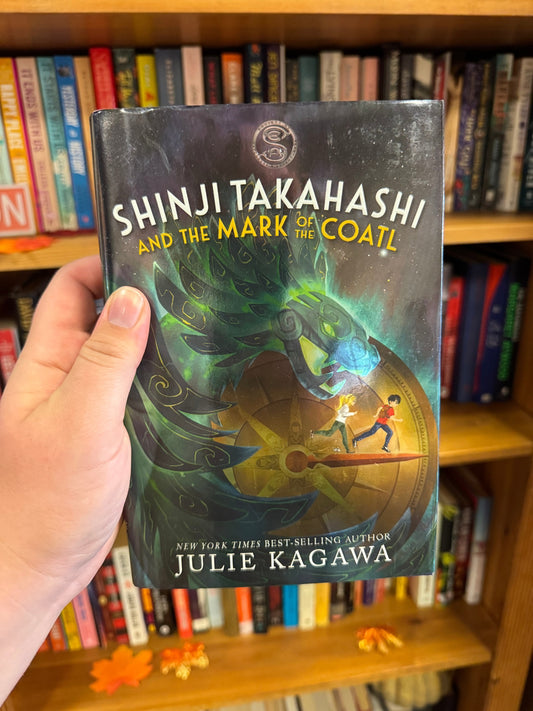 Shinji Takahashi and the Mark of the Coatl hardcover book by Julie Kagawa, dark cover with glowing green coatl serpent head illustration