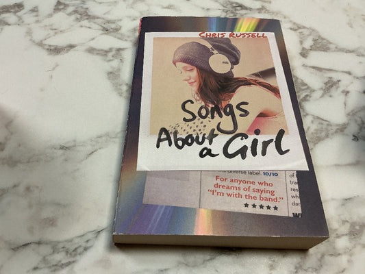 Book titled 'Songs About a Girl' by Chris Russell on a marble surface