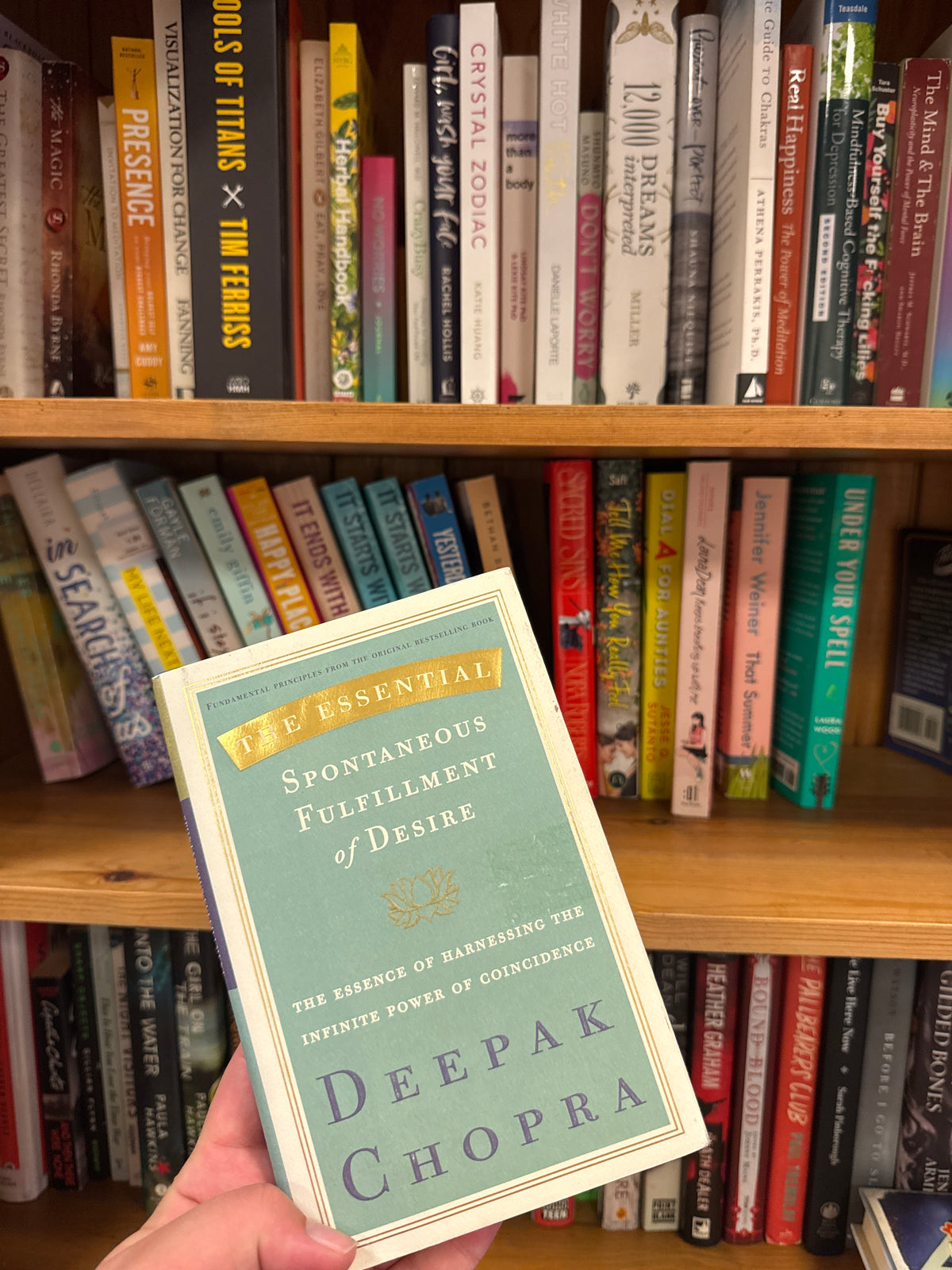 Softcover book The Essential Spontaneous Fulfillment of Desire by Deepak Chopra with teal and cream cover