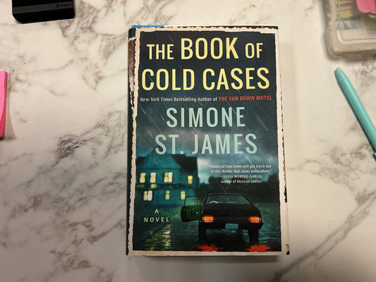 The Book of Cold Cases hardcover novel by Simone St. James with dark cover and car illustration