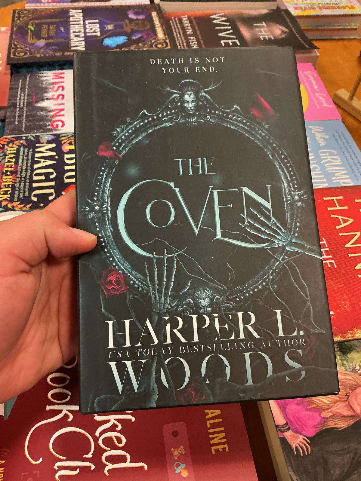 The Coven hardcover book by Harper L. Woods with gothic cracked mirror cover art
